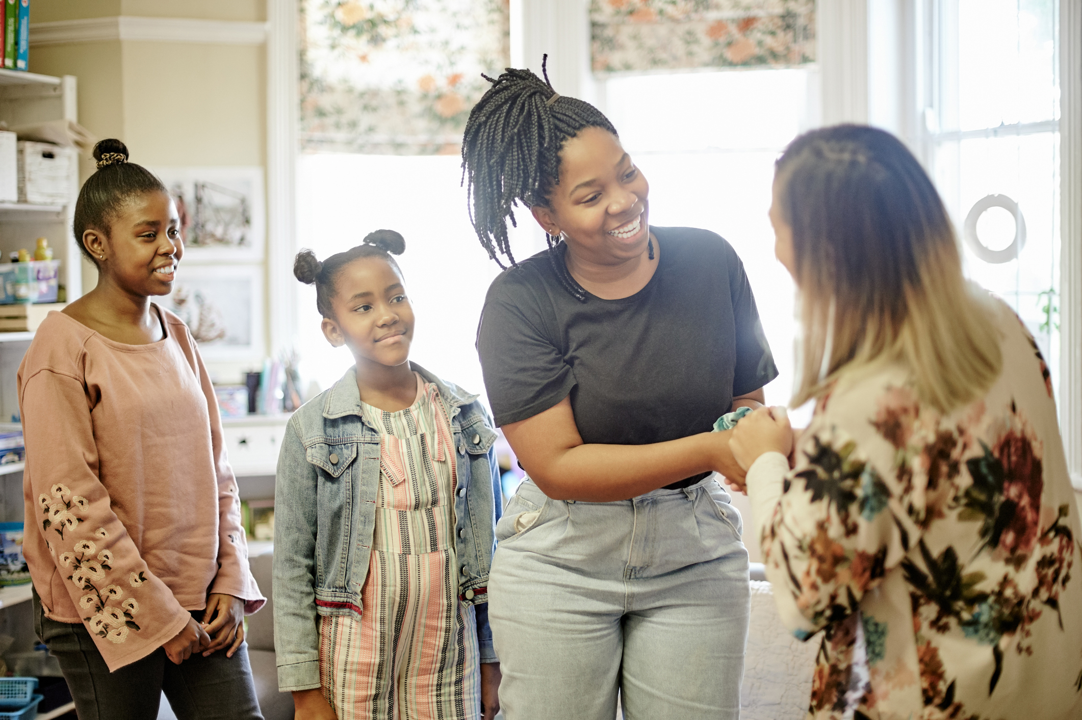 Two young Black female students and their guardian with an instructor.